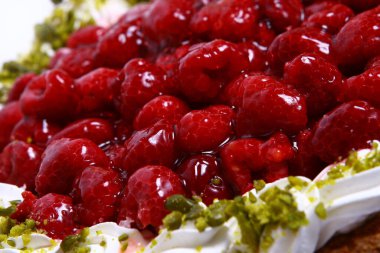 Lezzetli bir tatlı. Meyvelerle süslenmiş peynirli kek üzerine sos dökülmüş..