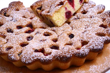 Lezzetli bir tatlı. Meyvelerle süslenmiş peynirli kek üzerine sos dökülmüş..