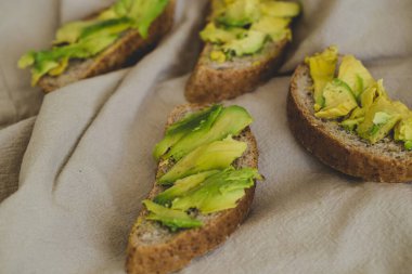 Tahta bir masada nefis avokado sandviçi.