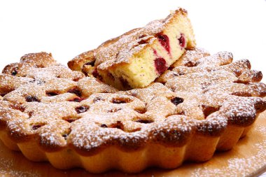 Lezzetli bir tatlı. Meyvelerle süslenmiş peynirli kek üzerine sos dökülmüş..