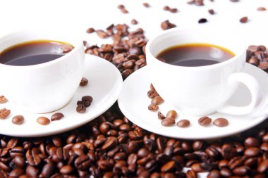 Masada beyaz bardaklı kahve çekirdekleri.