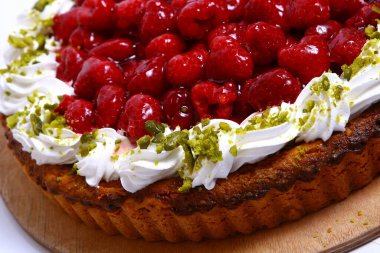 Lezzetli bir tatlı. Meyvelerle süslenmiş peynirli kek üzerine sos dökülmüş..