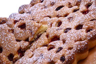 Lezzetli bir tatlı. Meyvelerle süslenmiş peynirli kek üzerine sos dökülmüş..