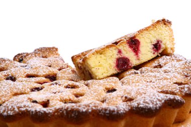 Lezzetli bir tatlı. Meyvelerle süslenmiş peynirli kek üzerine sos dökülmüş..