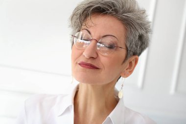 Sevimli, yaşlı ve mutlu yüzlü bir kadın.