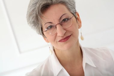 Güzel gülüşü olan tatlı, yaşlı bir kadın.