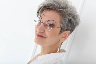 Güzel gülüşü olan tatlı, yaşlı bir kadın.