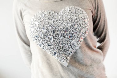 Tişörtte büyük, parlak bir kalp var.