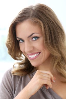 Çekici, güzel bir kadın, geniş gülüşlü.