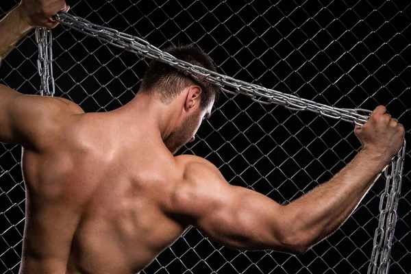 フェンスの背景に鎖を持つ美しい 強い男 — ストック写真