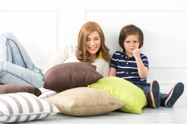 Yerde annesi olan sevimli, sevimli bir çocuk.