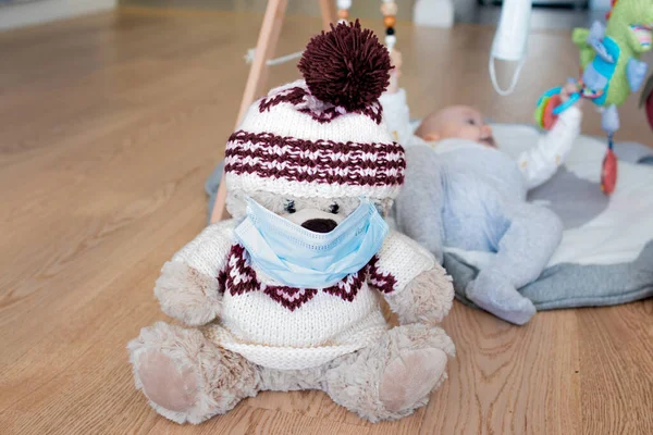 Bebek çocuk oyuncak ayısıyla Coronavirus Covid-19 sırasında maske takıyor Rusya 'da yayılıyor, Moskova arka planda yatıyor