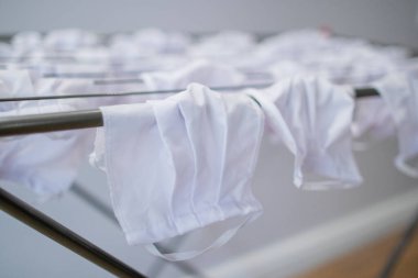 Yeniden kullanılabilir yüz maskeleri Coronavirus covid-19 'un güvenlik ve yüz koruma amacıyla yayıldığı zamanlarda dairenin içindeki kurutma askısında asılı duruyordu.