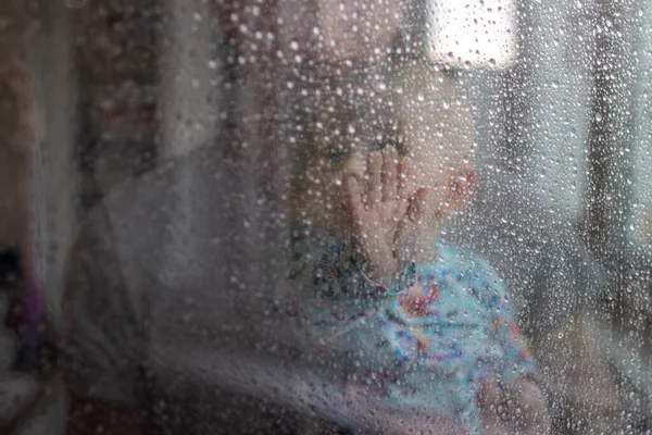 Biały Chłopiec Spoglądający Przez Szklane Okno Krople Deszczu Deszcz Zewnątrz — Zdjęcie stockowe