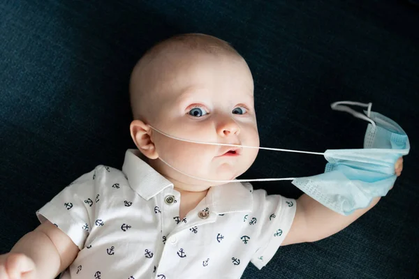 Beyaz, beyaz, beyaz, beyaz, beyaz, beyaz, beyaz bir erkek bebek. Mavi bir maske takıyor. Evde kalıyor. Coronavirus kovid sırasında 19 kez kendini izole edip maskesini çıkarmaya çalışıyor.