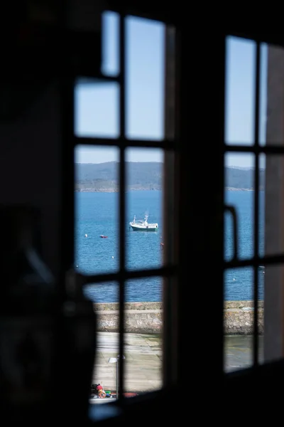 View from a window of the sea with boats sailing