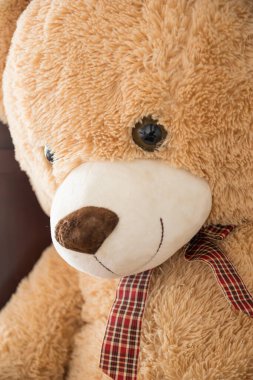 Çocuklarla oynamak ve hediyeler yapmak için papyonlu büyük kahverengi oyuncak ayı.