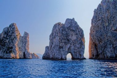 Faraglioni, Capri Denizi kıyısında, alacakaranlıkta.)