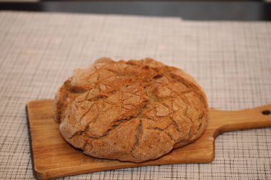 Siyah yuvarlak ev yapımı ekmek kesme tahtası üzerinde.