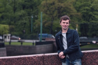 Fontanka Nehri dolgu üzerinde yürüyen genç adam. St. Petersburg tarihi merkezi.