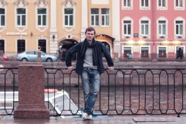 Fontanka Nehri dolgu üzerinde yürüyen genç adam. St. Petersburg tarihi merkezi.
