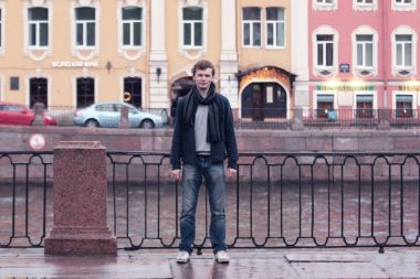 Fontanka Nehri dolgu üzerinde yürüyen genç adam. St. Petersburg tarihi merkezi.