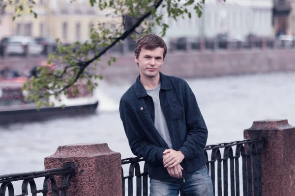 Fontanka Nehri dolgu üzerinde yürüyen genç adam. St. Petersburg tarihi merkezi.