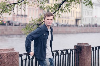 Fontanka Nehri dolgu üzerinde yürüyen genç adam. St. Petersburg tarihi merkezi.