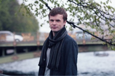 Fontanka Nehri dolgu üzerinde yürüyen genç adam. St. Petersburg tarihi merkezi.