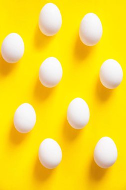 Sarı arka planda beyaz yumurtalar