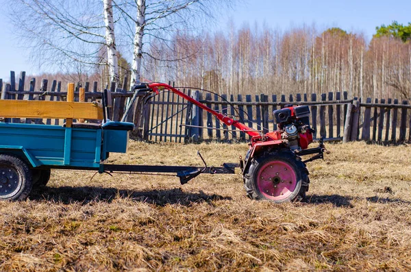 Pequeño mini tractor rojo se encuentra en un patio de la granja. Primavera y concepto de cosecha . —  Fotos de Stock