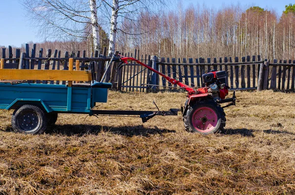 small mini red tractor stands on a farm yard. Springtime and harvest concept.