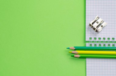 Okul konseptine geri dönelim. Okul ve ofis malzemeleri ofis masasında, yeşil arka plan. Kopyalama alanı olan düz.