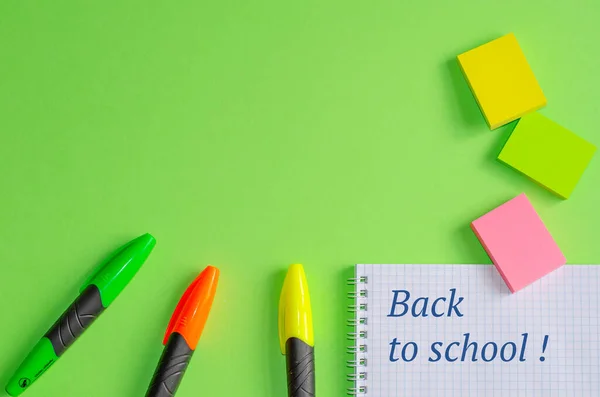 Tekst "Terug naar school" op schrift. School- en kantoorbenodigdheden op kantoortafel, groene achtergrond. Vlakke lay, kopieerruimte. — Stockfoto