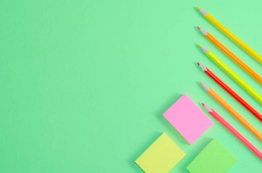 Okul konseptine geri dönelim. Okul ve ofis malzemeleri ofis masasında, yeşil arka plan. Kopyalama alanı olan düz.