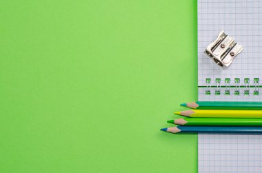 Okul konseptine geri dönelim. Okul ve ofis malzemeleri ofis masasında, yeşil arka plan. Kopyalama alanı olan düz.