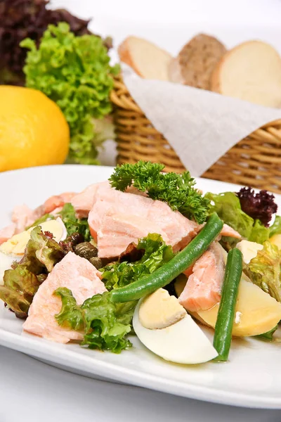 Ensalada de salmón con espárragos en un plato blanco con hierbas frescas — Foto de Stock