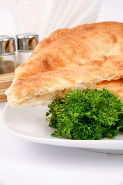 Beyaz bir plaka üzerinde ev yapımı ekmek maydanoz ile dekore edilmiştir.