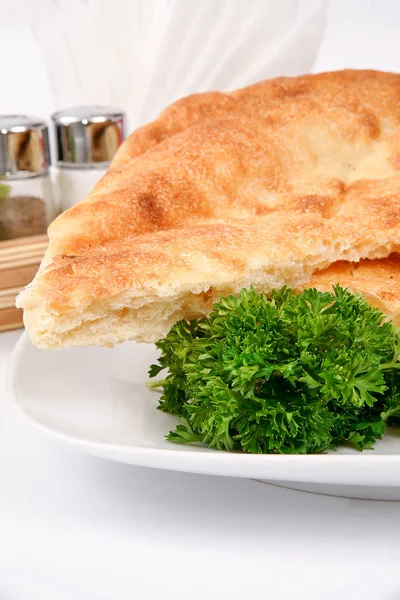 Homemade bread on a white plate decorated with parsley — Stock Photo, Image