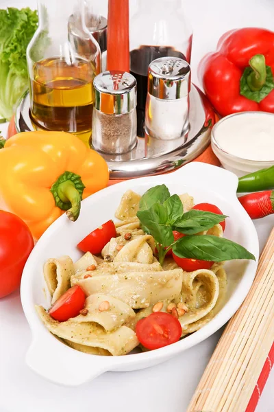 Pasta with pesto and tomatoes decorated with parsley and dill in — Stock Photo, Image