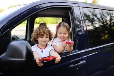 children look out from a car window clipart