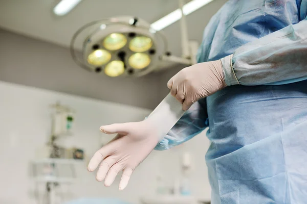 Chirurg, zakładanie rękawic gumowych przed operacją trudną — Zdjęcie stockowe