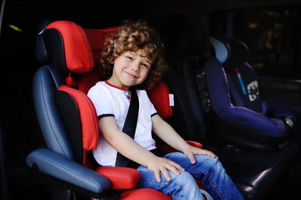 Baby boy sitting in a red child car seat — Stock Photo, Image