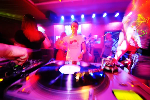 DJ behind the decks in a nightclub.