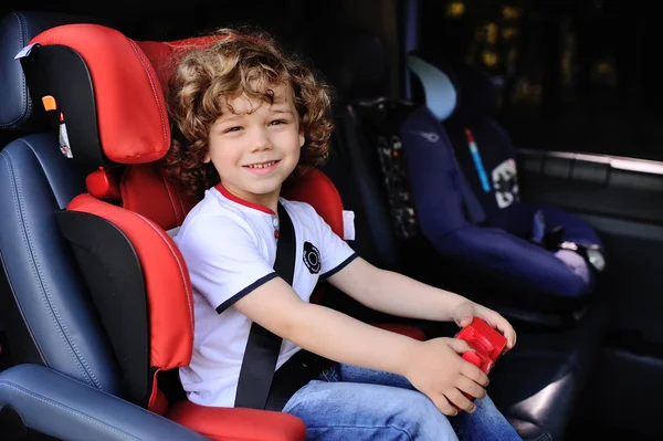 Curly-haired child in the car seat — Stock Photo, Image