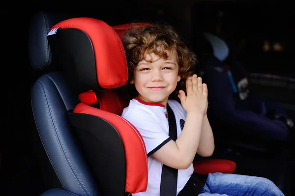Baby boy sitting in a red child car seat — Stock Photo, Image