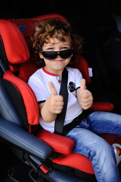 Baby boy sitting in a red child car seat — Stock Photo, Image