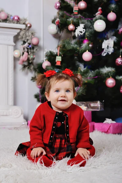 Niña en un vestido rojo en el fondo del árbol de Navidad — Foto de Stock