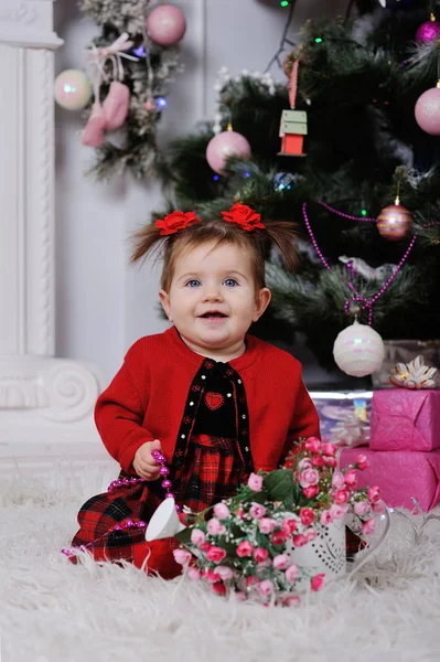 Niña en un vestido rojo en el fondo del árbol de Navidad —  Fotos de Stock
