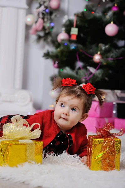 Niña en un vestido rojo en el fondo del árbol de Navidad —  Fotos de Stock